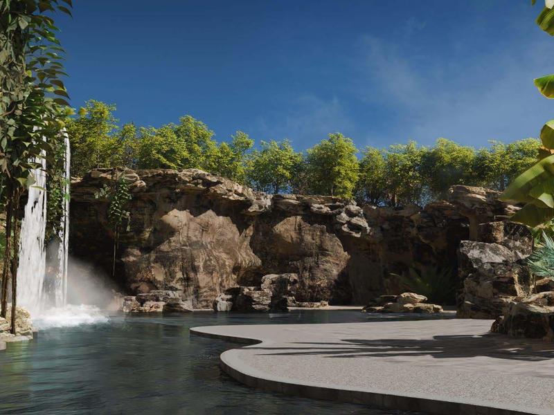 Groot zwembad met waterval en rotsen in een tropische hotelomgeving onder een blauwe lucht.