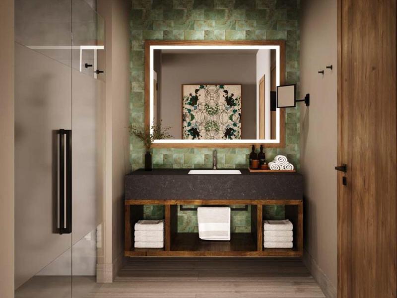 Moderne badkamer met verlichte spiegel, houten wastafel en glazen deur naar de douche.