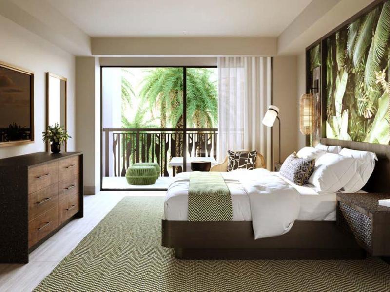 Modern hotelkamer met balkon, tweepersoonsbed, tv, ladekast en tropisch uitzicht.