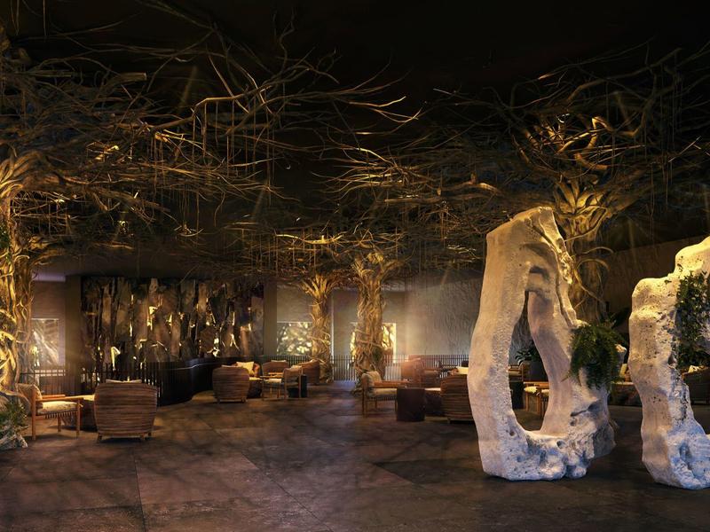Elegante hotel lounge met warme verlichting, sculpturen en gezellige zithoeken met planten.
