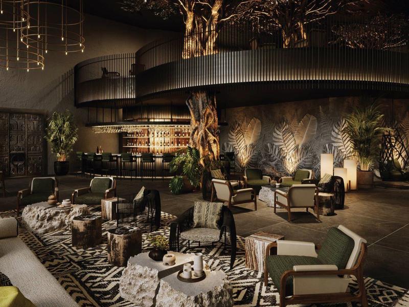 Luxueuze hotellounge met moderne meubels, boomsculptuur en sfeerverlichting.