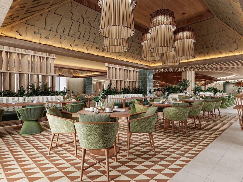 Ruime restaurantruimte met decoratieve lampen, groene stoelen en een patroon op de vloer.