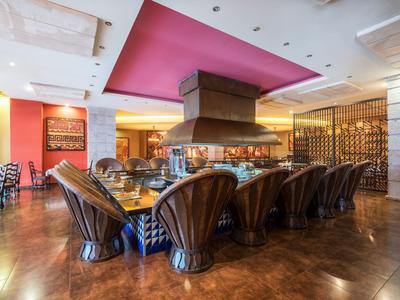 Elegantes Restaurant mit großen bequemen Stühlen und einem zentralen Kamin.