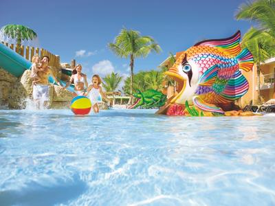 Kleurrijk kinderzwembad met vissen glijbaan en waterval onder blauwe lucht