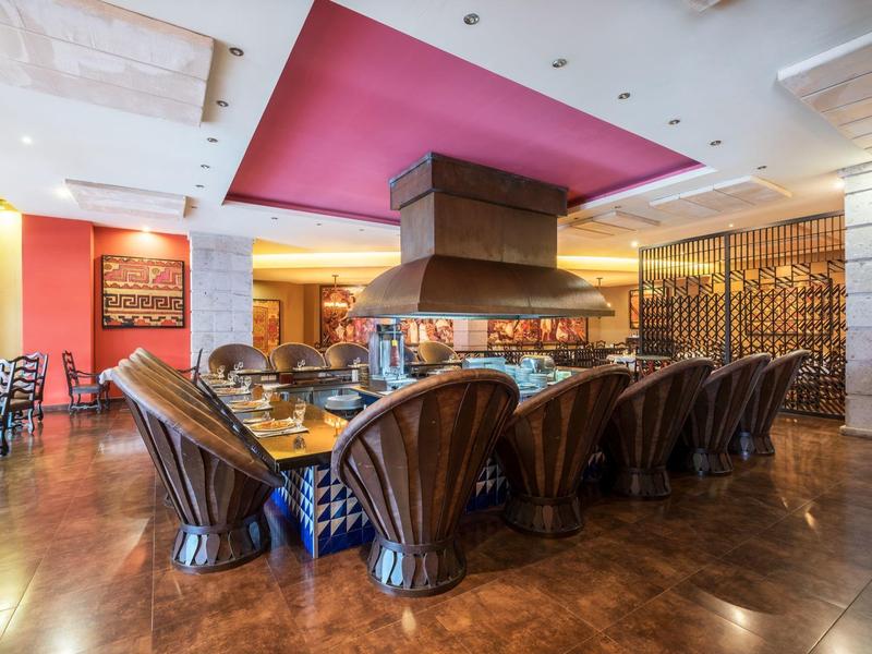 Luxe eetruimte met ovale tafel, comfortabele stoelen en open haard in een elegant hotelrestaurant.