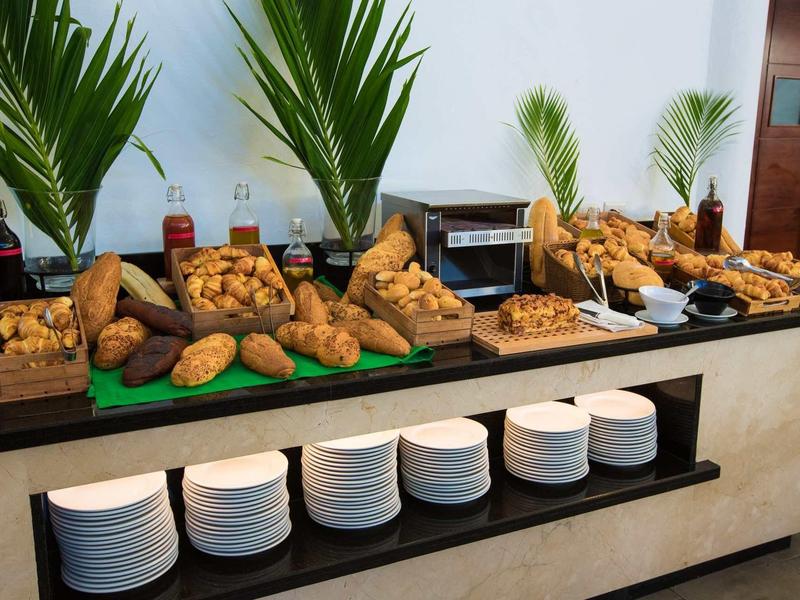 Buffet mit verschiedenen frisch gebackenen Broten und Gebäck auf grünemblättrigem Tischdekor.