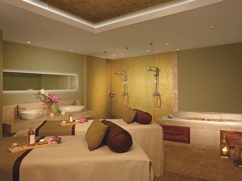 Luxuriöser Spa-Raum mit Massagebetten, freistehender Badewanne und gedämpfter Beleuchtung.