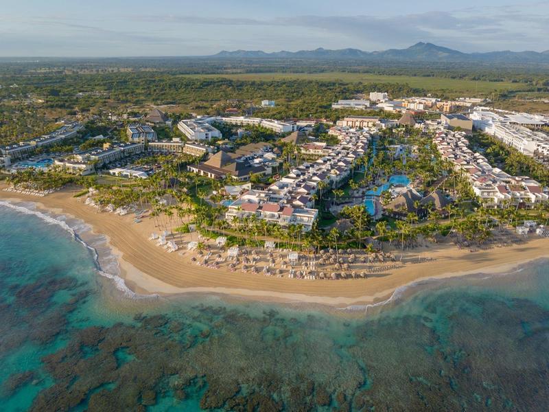 Luftaufnahme eines Resorts mit Sandstrand, Poolanlagen und angrenzendem Meer