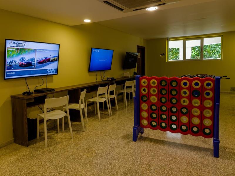 Una sala giochi con grandi schermi, scrivanie e un grande gioco Forza 4.