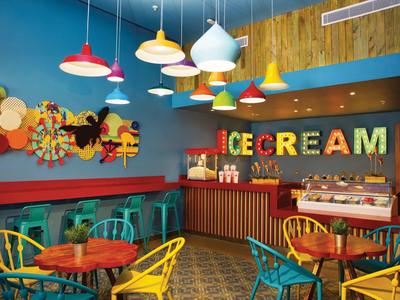 Bunte Eisdiele mit bunten Stühlen und Lampen in lebhaftem Ambiente.