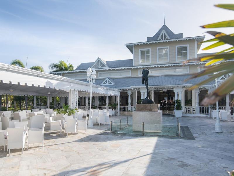 Na zewnątrz hotelu taras z białymi krzesłami i centralną fontanną.