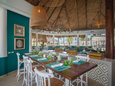 Open restaurant area with set table and tropical decor in a hotel.