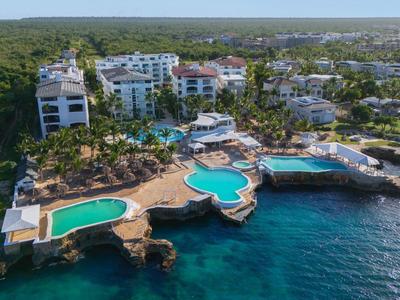 Letecký pohled na přímořské letovisko s několika bazény a čistou mořskou vodou