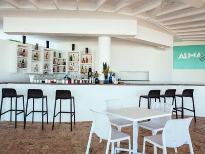 Moderní bar s elegantními stoličkami, stoly a židlemi v jasné místnosti.