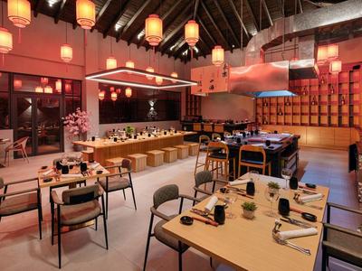 Ristorante arredato modernamente con illuminazione calda e decorazioni eleganti.