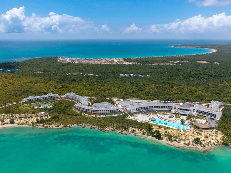 Luxuriöses Hotel am türkisfarbenen Meer mit großen Pools und viel Grün umgeben.
