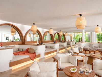 Spacious hotel lounge with arched windows, comfortable seating, and warm lighting fixtures.