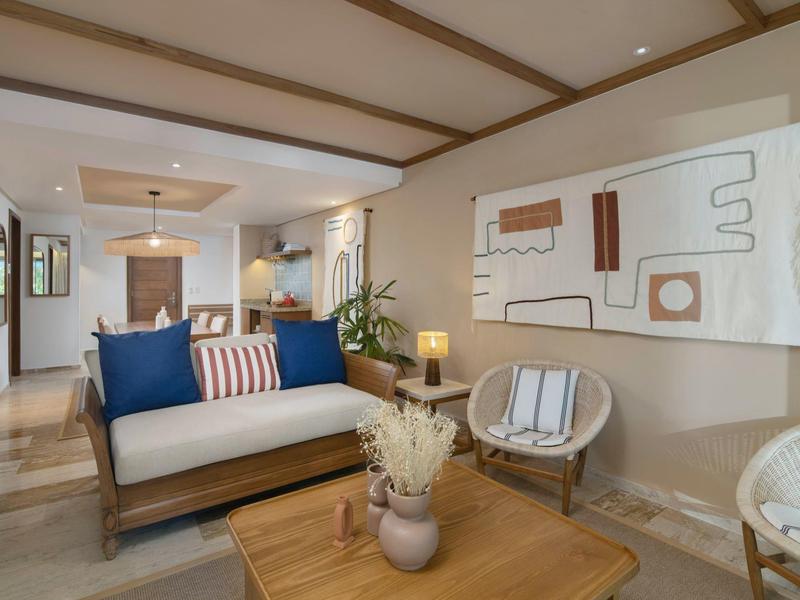 Cozy living room with beige walls, wooden furniture, and abstract wall art.