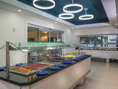 Buffetbereich mit verschiedenen Speisen und modernem Deckenlicht in einem Hotelrestaurant.