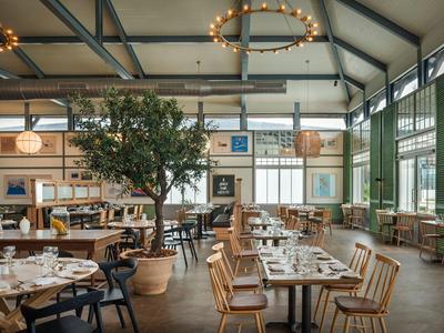 Spacious, bright dining room with wooden furniture and green walls in a hotel.