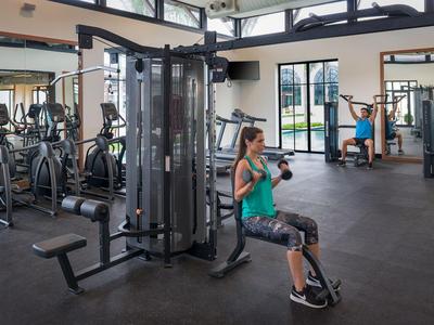 Gym with modern equipment and two people working out in a bright fitness studio.