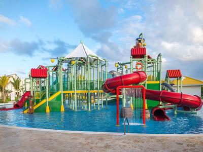 Wasserpark mit buntem Kinderspielplatz und Rutschen in einem Pool unter blauem Himmel.