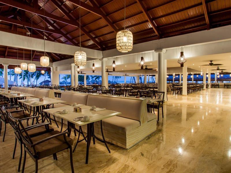 Ristorante moderno con tetto in legno, panche e sedie in un'area aperta al crepuscolo.