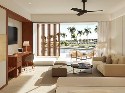 Moderner Hotelzimmer mit Sofa, Schreibtisch und Balkon mit Blick auf Palmen und Wasser