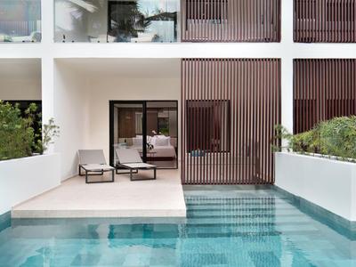 Moderner Innenhof mit Pool, Liegestühlen und Sicht auf Schlafzimmer durch Glaswand