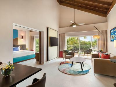 Sala luminosa con techo de madera, grandes ventanas y acceso a terraza con vista al jardín.