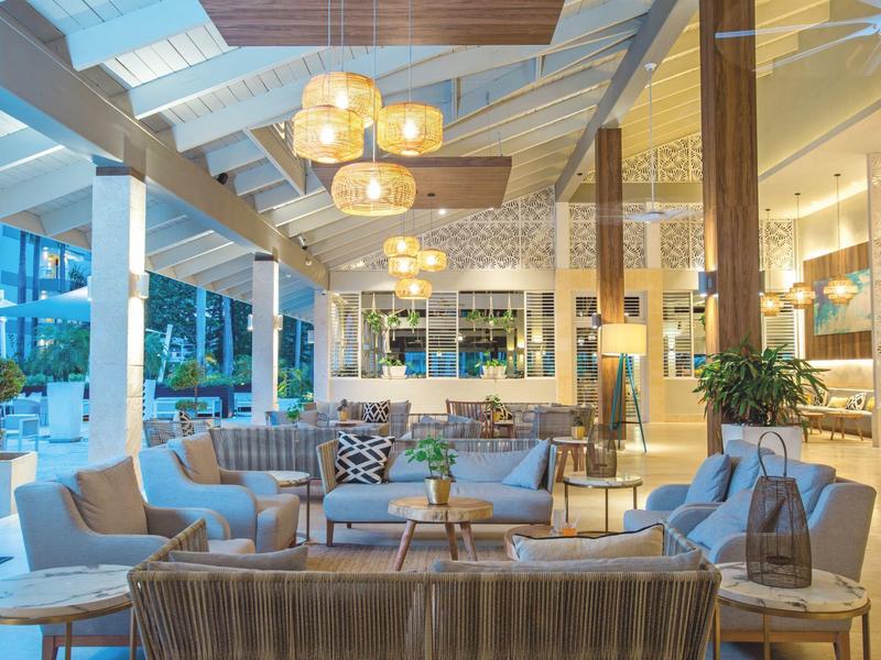 Área de lobby de hotel moderno con cómodos asientos y luz cálida.