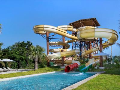 Scivoli d'acqua multipista in un'area piscina di un resort sotto un cielo azzurro.
