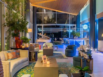 Moderne hotel lobby met gezellige zitplaatsen, planten en stijlvolle verlichting.