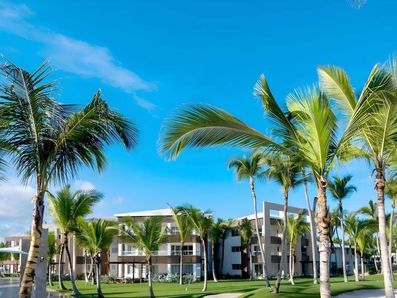 Hotelgebouw met hoge palmbomen en blauwe lucht in tropisch resort