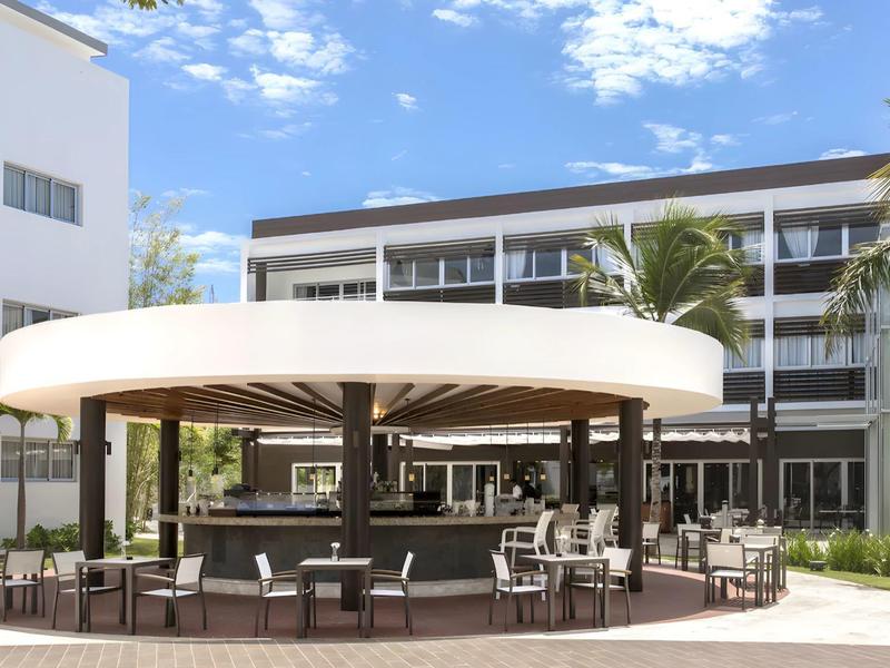 Moderne hotelzwembadgebied met ronde barpaviljoen en zitplaatsen buiten.