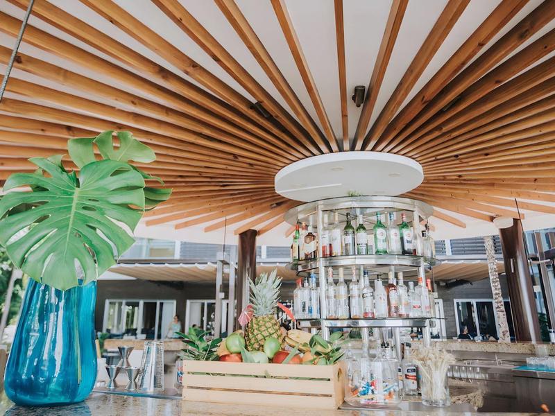 Moderne hotelbar met houten plafond en centrale ronde plank.