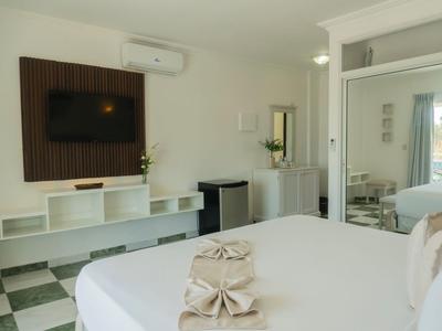 Camera d'hotel moderna con letto grande, TV a parete e piccola scrivania.