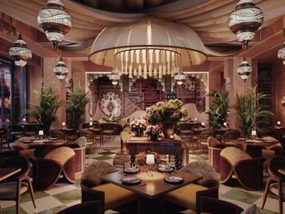 Elegancka restauracja z okrągłym kominkiem, luksusową dekoracją i wygodnymi miejscami do siedzenia.