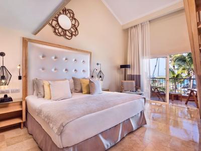 Elegantes Hotelzimmer mit großem Bett, Balkon und moderner Einrichtung.