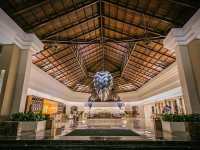 Prostorná hotelová hala s dekorativním stropem a centrální sochou lva.