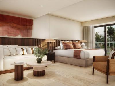 Jasný hotelový pokoj s velkou postelí, pohovkou, křesly a balkonem s výhledem na palmy.