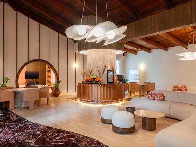 Modern hotel lounge area with cozy sofas and wooden ceiling.