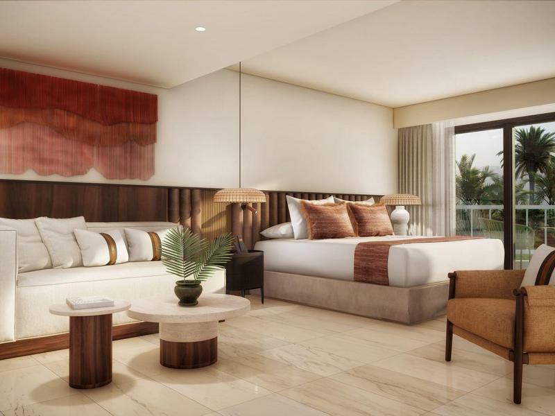 Jasný hotelový pokoj s velkou postelí, pohovkou, křesly a balkonem s výhledem na palmy.