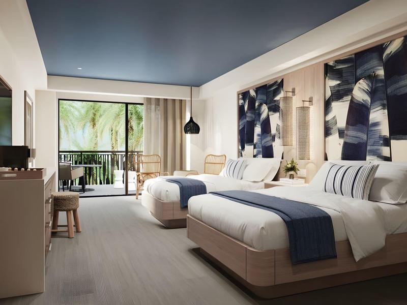 Habitación de hotel moderna con dos camas, ventana grande y balcón con vista tropical.