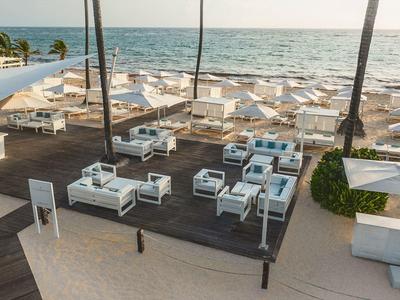 Nowoczesny taras na zewnątrz z białymi meblami i widokiem na morze na słonecznej plaży