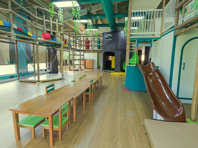 Przyjazna dla dzieci przestrzeń do zabawy z stołami i zjeżdżalnią w hotelu.