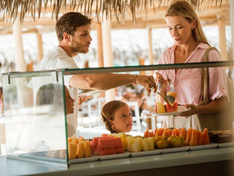 Rodzina wybiera świeże owoce w bufecie w tropikalnym miejscu wypoczynku.