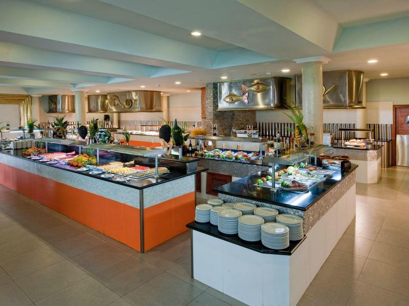 Buffet room with long, colorful buffet stations and various dishes in a modern hotel.