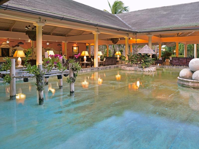 Open hotel restaurant with outdoor pool and elegant lighting at dusk.