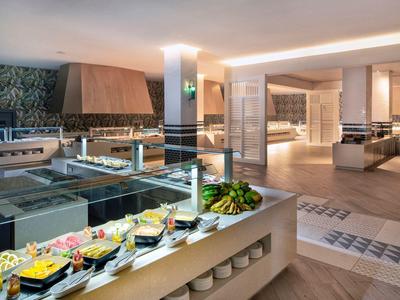 Modernes Buffet mit vielfältigen Speisen, helle Beleuchtung und elegante, helle Raumgestaltung.